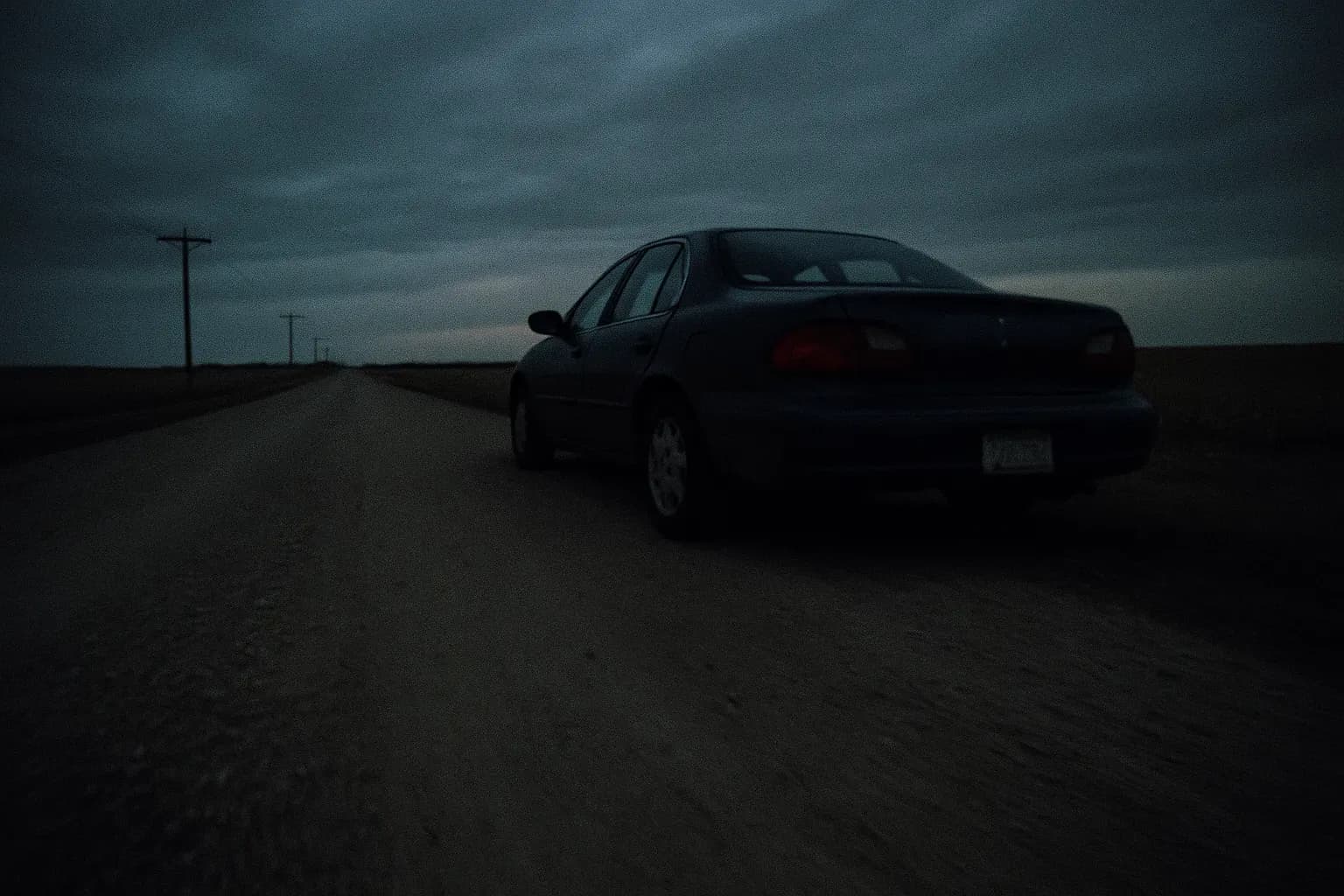 A lone car sits abandoned on a rural Minnesota road near Taunton, surrounded by open fields, hinting at the unsolved mystery of Brandon Swanson's disappearance.